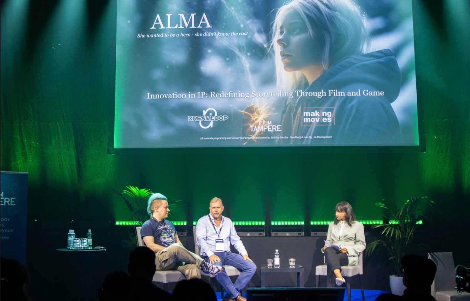 People attending a gaming industry event in a green-lit venue.